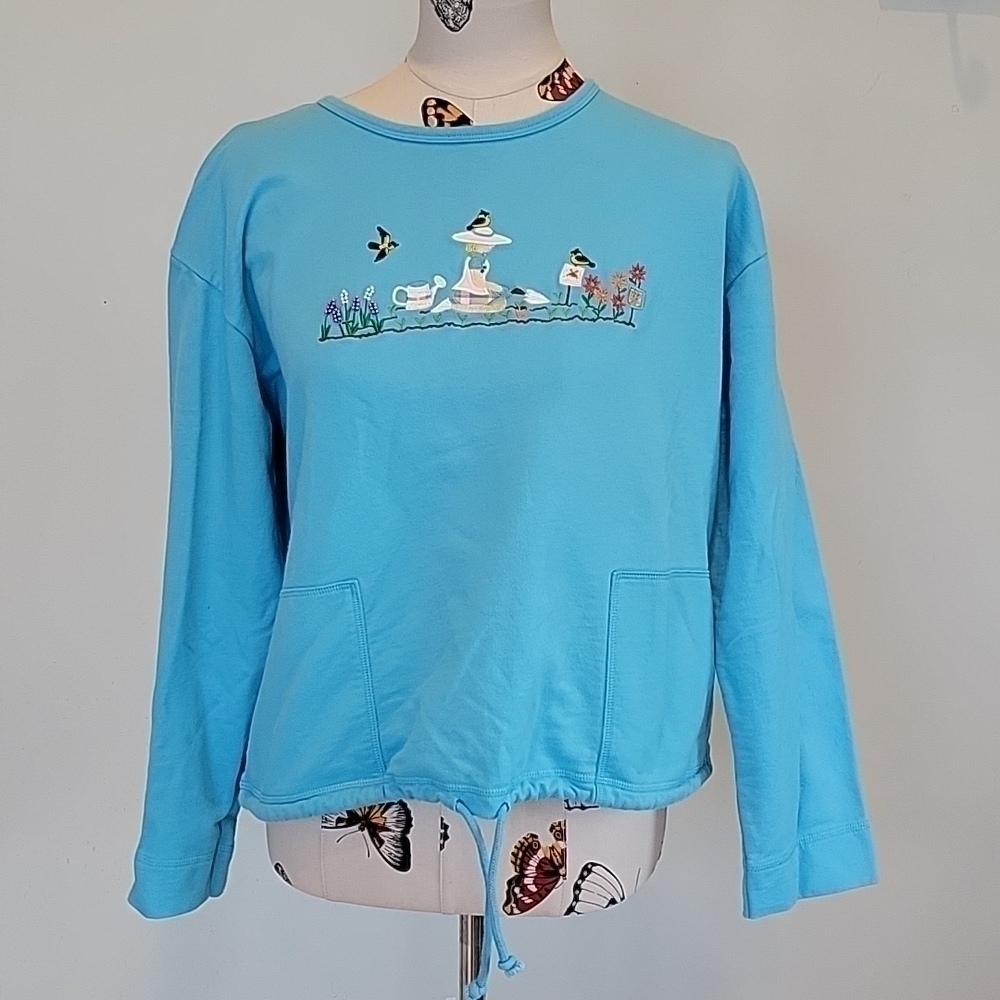 mandal BAY blue sweatshirt with an embroidered gardening scene. Size Large